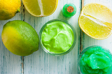 beauty care cosmetic cream samples with citrus fruits on white wood