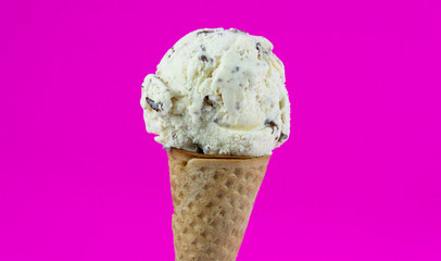 Cookies & Cream ice cream scoop in waffle cone on pink background, Closeup Front view Food concept..