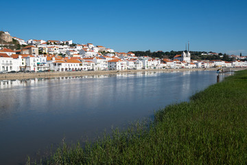 Fototapeta na wymiar View of Alcacer do Sal cityscape from the other side of the Sado river