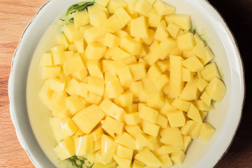 Raw sliced potatoes lay in plate of water to get rid of nitrates and nitrites.