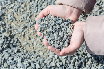 Girls hands hold small stones.