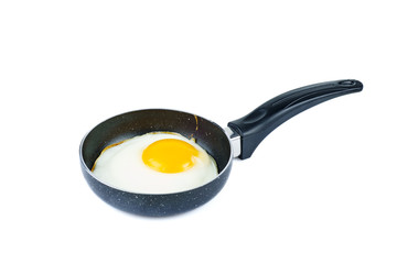 Fried egg in a tiny pan isolated on white background