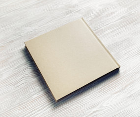 Photo of blank square booklet on light wood table background. Copy space for text.