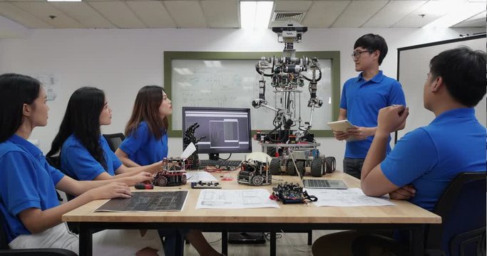 Asian man engineer present robot innovation with architects design team in laboratory. Team meeting share technology ideas and collaborating development robot. Concept of presentation robot technology