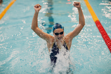 Young woman swimmer portrait joy rejoices in victory in swimming competitions in swimming pool. Win concept.