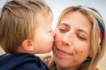 Close,up of baby son kissing on mothers cheek