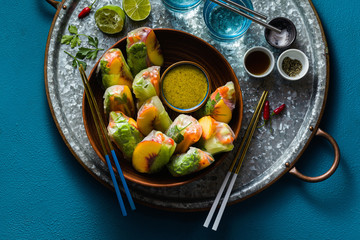 vegan spring rolls of vegetables and peach with pistachio sauce on a tray. healthy food . shot from above. copy space