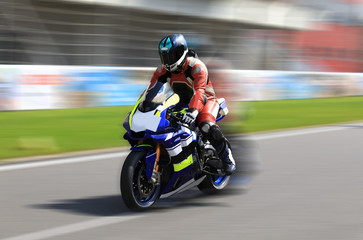 Obraz na płótnie Canvas Racer on a sports bike rides on the race track