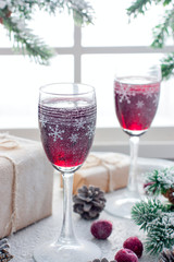Festive berry liqueur in glass Christmas glasses on the table in the Christmas decorations, selective focus