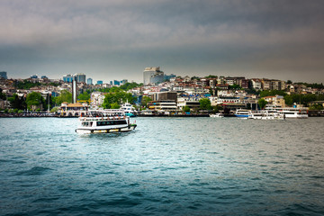 Fototapeta premium Ferry on sea with cityscape in background