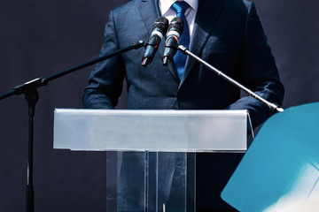Male Speaker Standing In Front Of Microphones