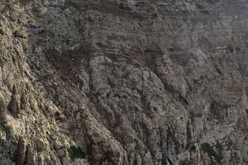 The lava which has stiffened several centuries ago has turned gray from time. Natural pattern on a steep slope