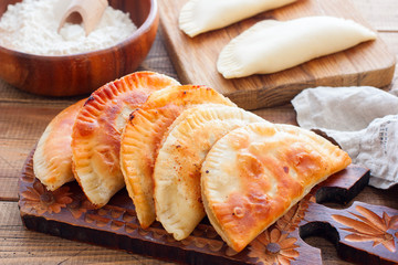 Homemade pasties on a wooden board, horizontal