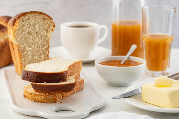 Freshly brioche bread and butter, juice and jam. Continental breakfast.