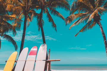 Surfboard and palm tree on beach background.