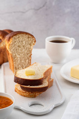 Freshly brioche bread and butter, juice and jam. Continental breakfast.