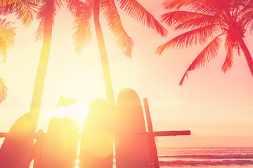 Surfboard and palm tree on beach background.