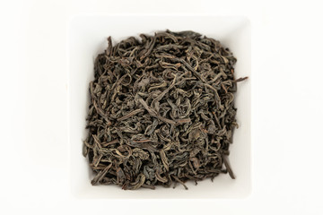 Full leaf black tea on a white plate. Top view