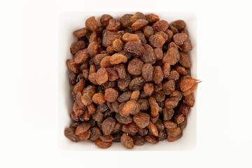white bowl with raisins on white background. Top view