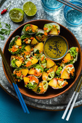 vegan spring rolls of vegetables and peach with pistachio sauce on a tray. healthy food . shot from above. copy space