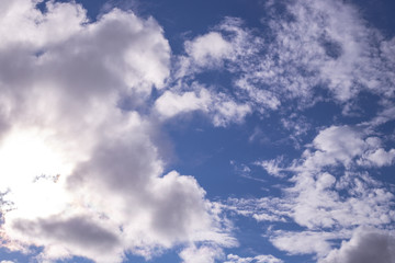 blue sky and sun shine through white clouds