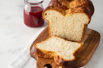 Fotobehang Delicious homemade organic fresh brioche bread on white table. © Natallia