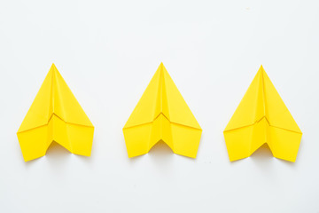 Team spirit and ambition. Three yellow paper airplanes isolated on white background. Copy space.