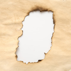 Aged wrinkled beige paper with burnt hole on white background. Grunge abstract design. Copy space.