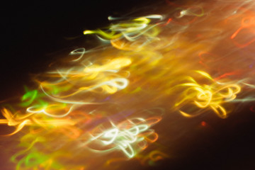 Blur yellow and white glowing swirly lines flow. Colored smoke effect. Dark abstract art background.