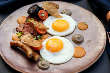 beautiful english breakfast with two eggs and pork sausage