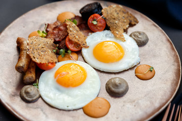 beautiful english breakfast with two eggs and pork sausage