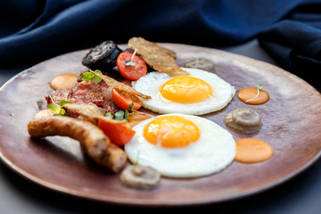 beautiful english breakfast with two eggs and pork sausage