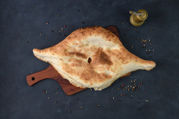 Georgian bread lavash on wooden board on dark rustic background, top view