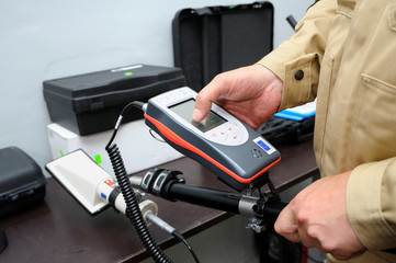 New radiation detectors testing. Dosimetrist adjusting a portable gamma radiation dosimeter 