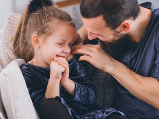 Happy parenting lifestyle. Caring father complementing his cute little daughter, girl feeling shy,...