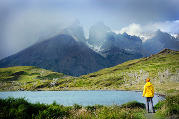 Active girl enjoy the view on amazing mountain landscape with Los Cuernos rocks and Lake Pehoe in Torres del Paine national park duting hiking in the mountains, Patagonia. Chile