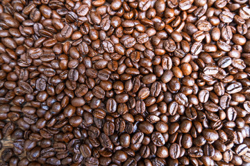 Coffee beans are on brown wooden table background