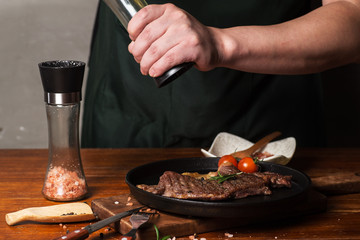 The cook marinated a steak with black pepper