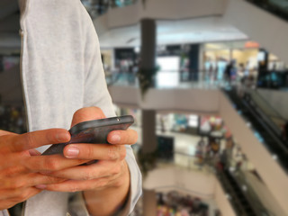 man using mobile phone payment in department store
