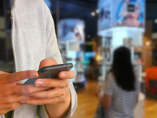 man using mobile phone payment in department store
