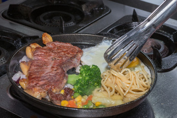 Fried steak with eggs and pasta