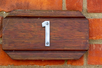 House number 1 on a red brick wall