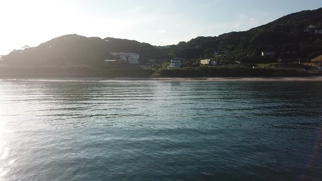 海岸から遠ざかる 海面に反射する太陽 朝 空撮 トラックバック 後退 低空 v09_252(DJI_0004)