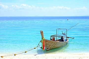 Obraz premium Side view traditional fishing boat floating on the bright blue sea at Poda island, Krabi, Thailand.
