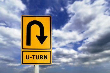 U-turn sign board with blue sky