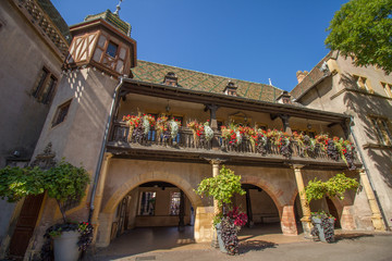 Historisches Gebäude mit bunten Ziegeln, Fachwerk, Torbögen und Blumen Altstadt von Colmar im Elsass, Frankreich