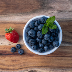 blueberries in a bowl on wooden table