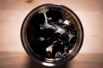 top view of milk forms in coffee on wooden board background