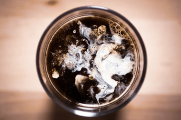 top view of milk shapes in coffee on a wooden board background