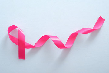 Fototapeta na wymiar Pink breast cancer ribbon on blue background. Breast cancer awareness month concept